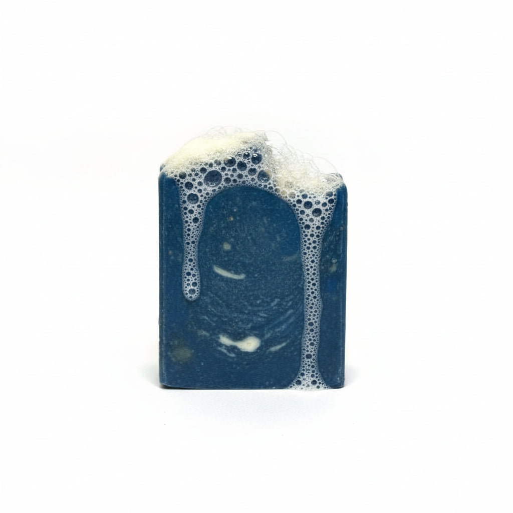 Blue soap bar with white lather on a white background